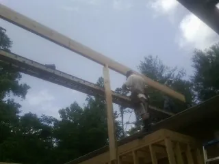 Carpenter setting a ridge beam over a new addition frame — Ice Dam Removal by Roofing Brothers in Mill Valley