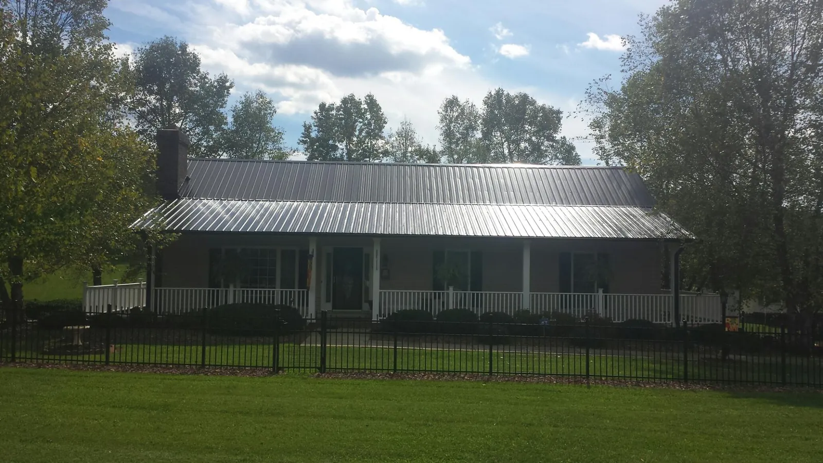 Gray metal roof on a brick ranch with a full width front porch — Gutter Guard Installation work by our crew in Mill Valley